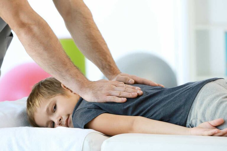 Adult seated near a therapist while discussing dizziness and balance symptoms in a bright clinical room.